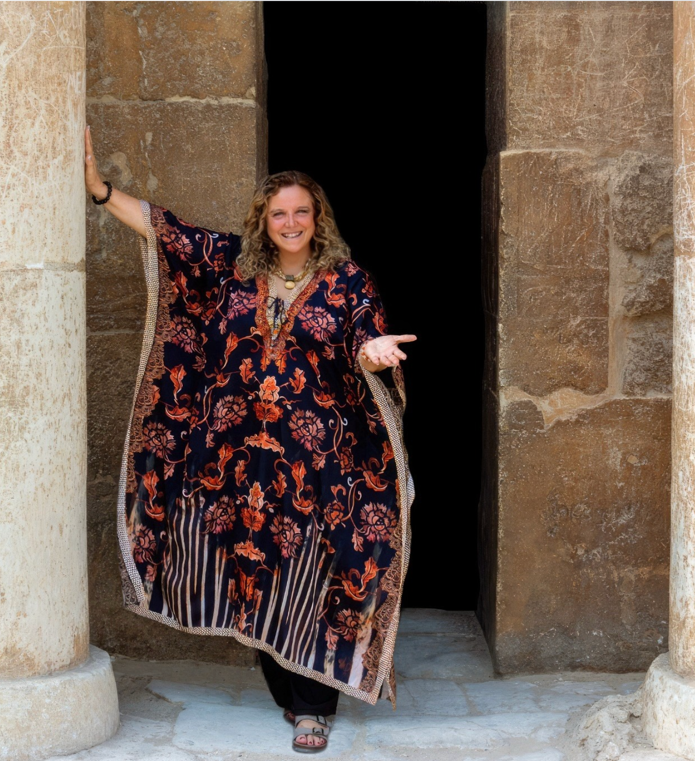 Shakti standing at the threshold of an ancient Egyptian temple, extending her hand in welcome